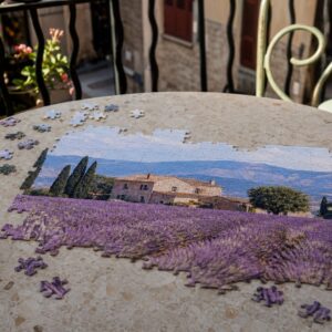 Fotopuzzel van een lavendelveld die op een ronde tafel op een balkon wordt gelegd